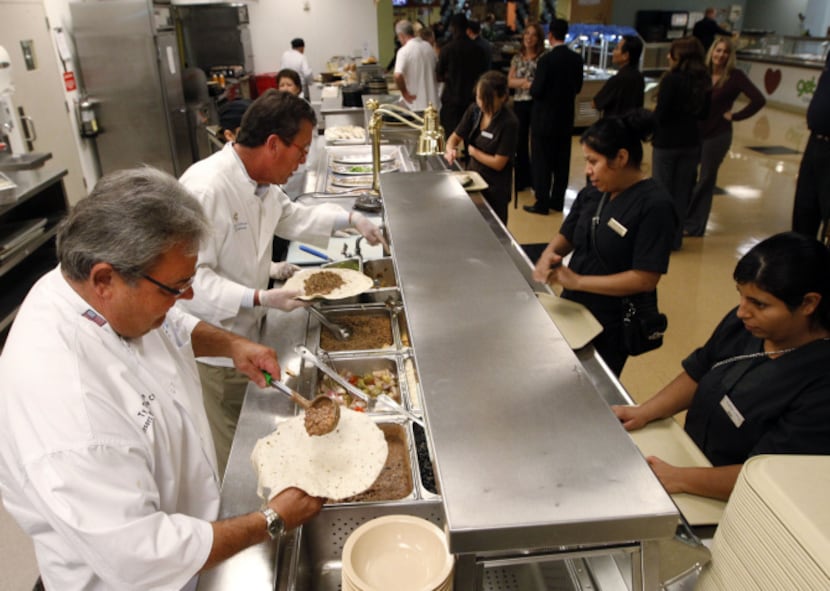 Ty Thoren, left, and Rick Ricci serve lunch to fellow employees at the Gaylord Texan Resort...