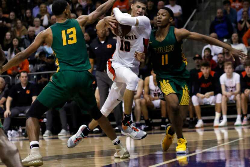 Rockwall senior guard Samuell Williamson (10) drives hard to the basket between the defense...