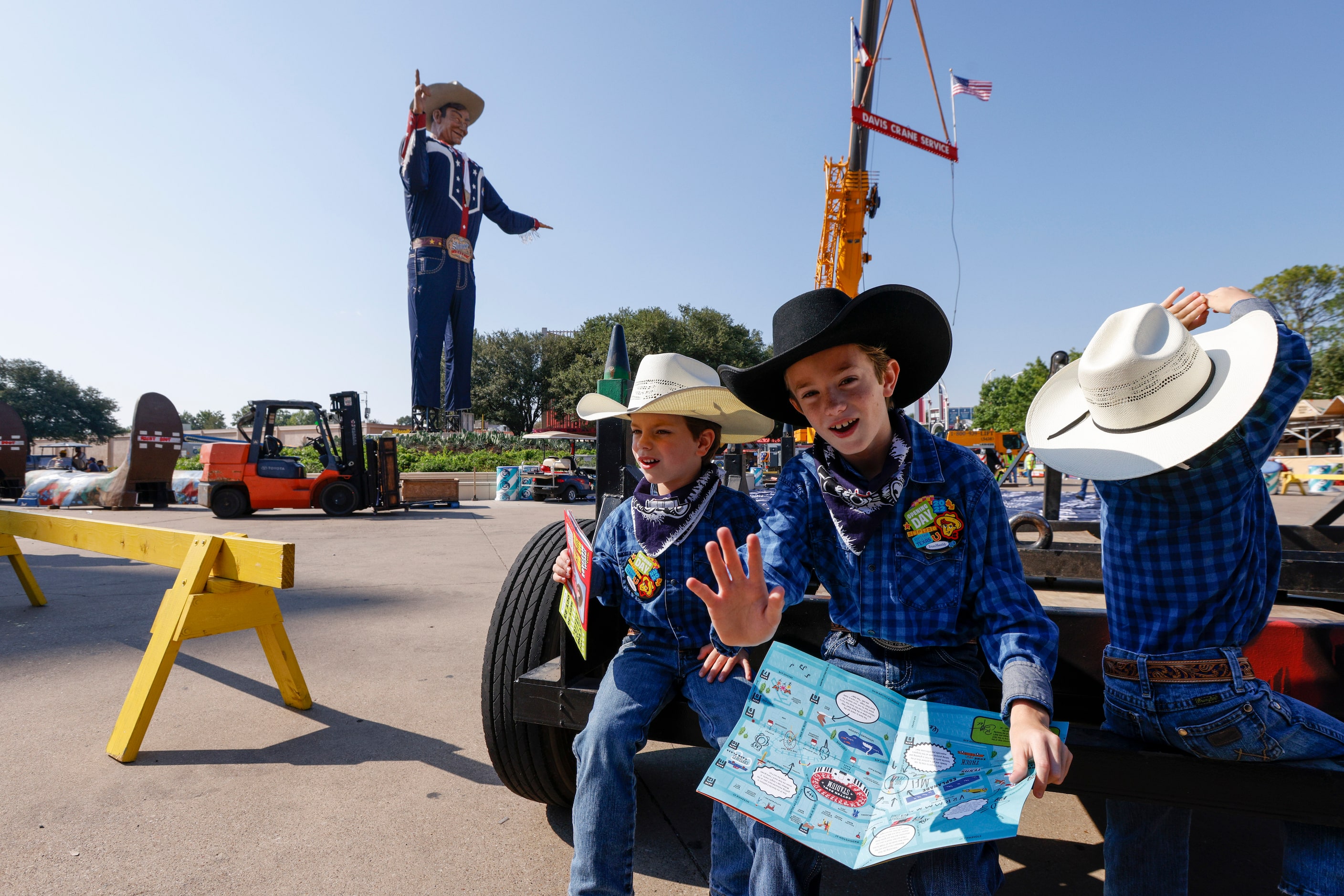 Isaiah Lee, 9, waves alongside his twin brothers Zachary, 5 (left), and Zane after watching...