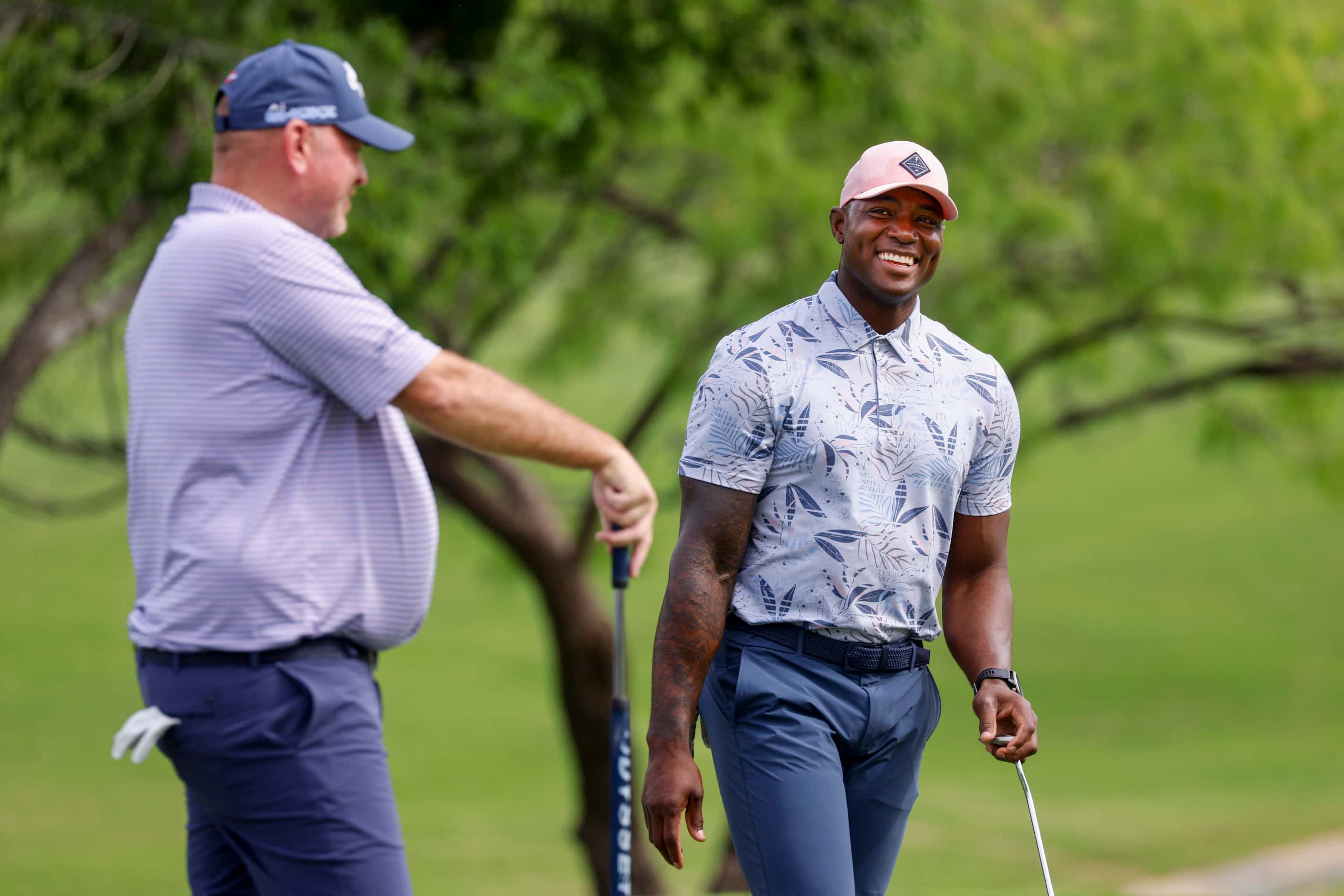 Former Dallas Cowboys player DeMarcus Ware smiles as he talks with professional golfer...