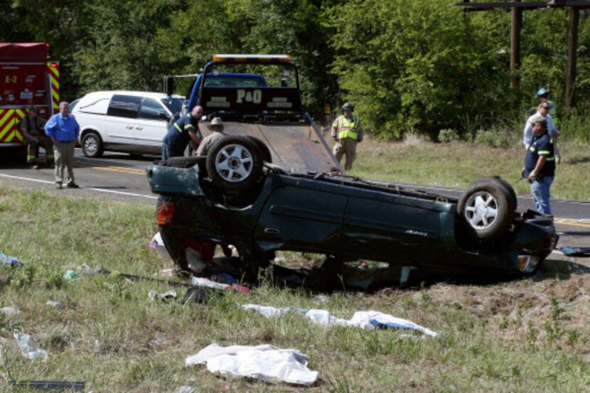 Officials work the scene of an accident where a sport utility vehicle taking 10 children to...