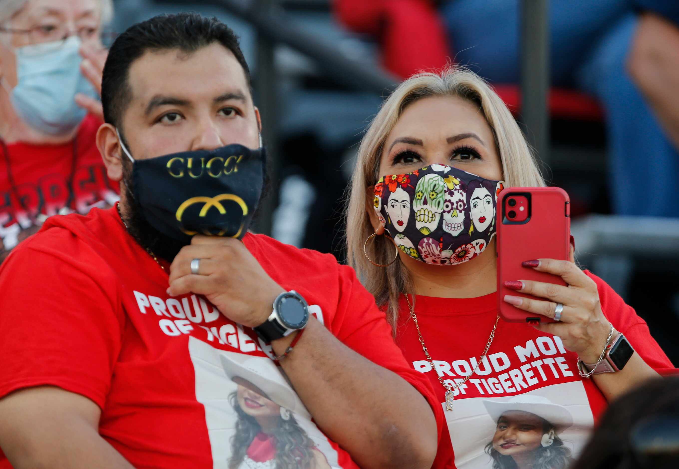 Two Terrell fans wear various face masks during the first half of  a high school football...