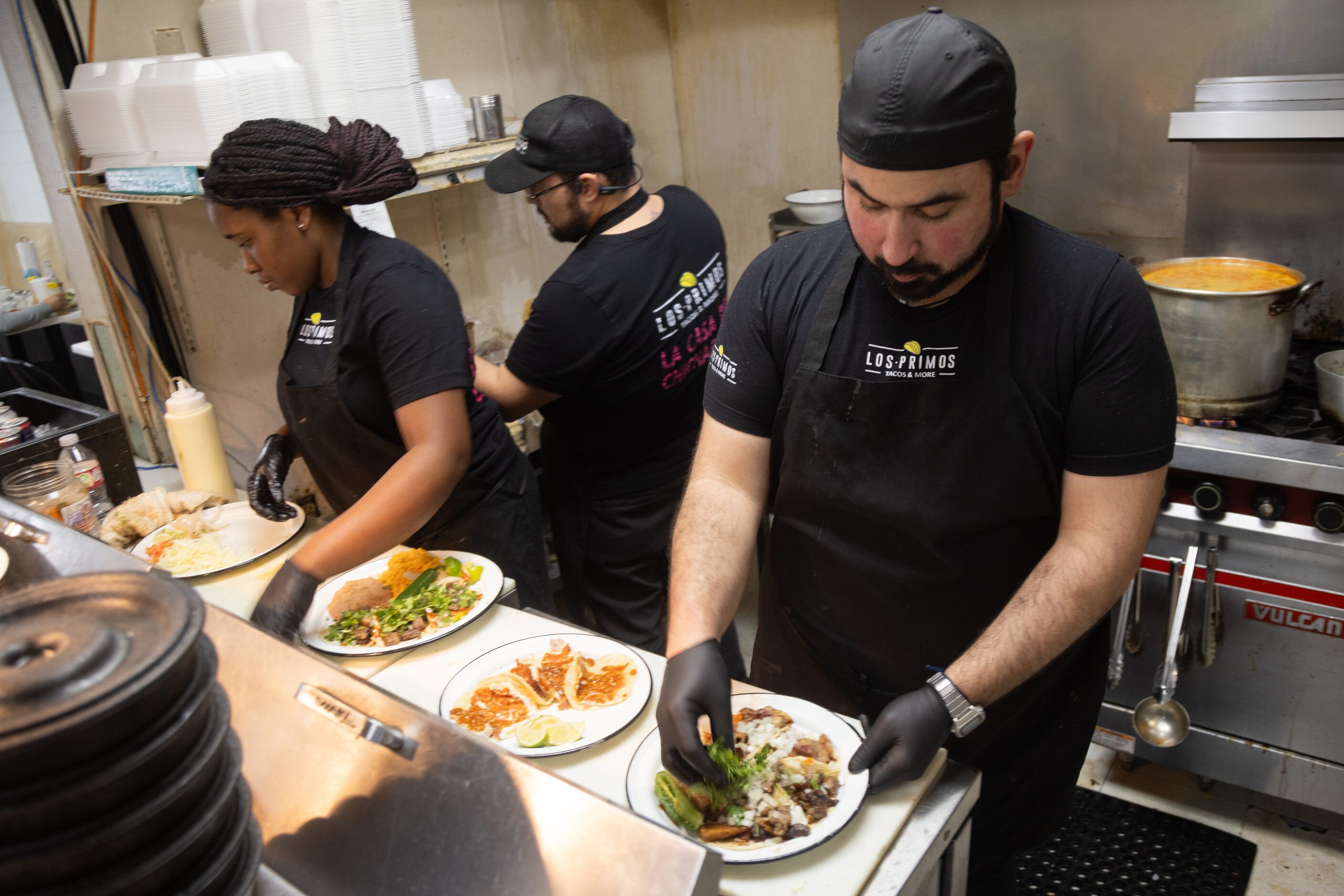 Paco Galván, one of the owners of Los Primos Tacos & More, prepares a taco plate at his...