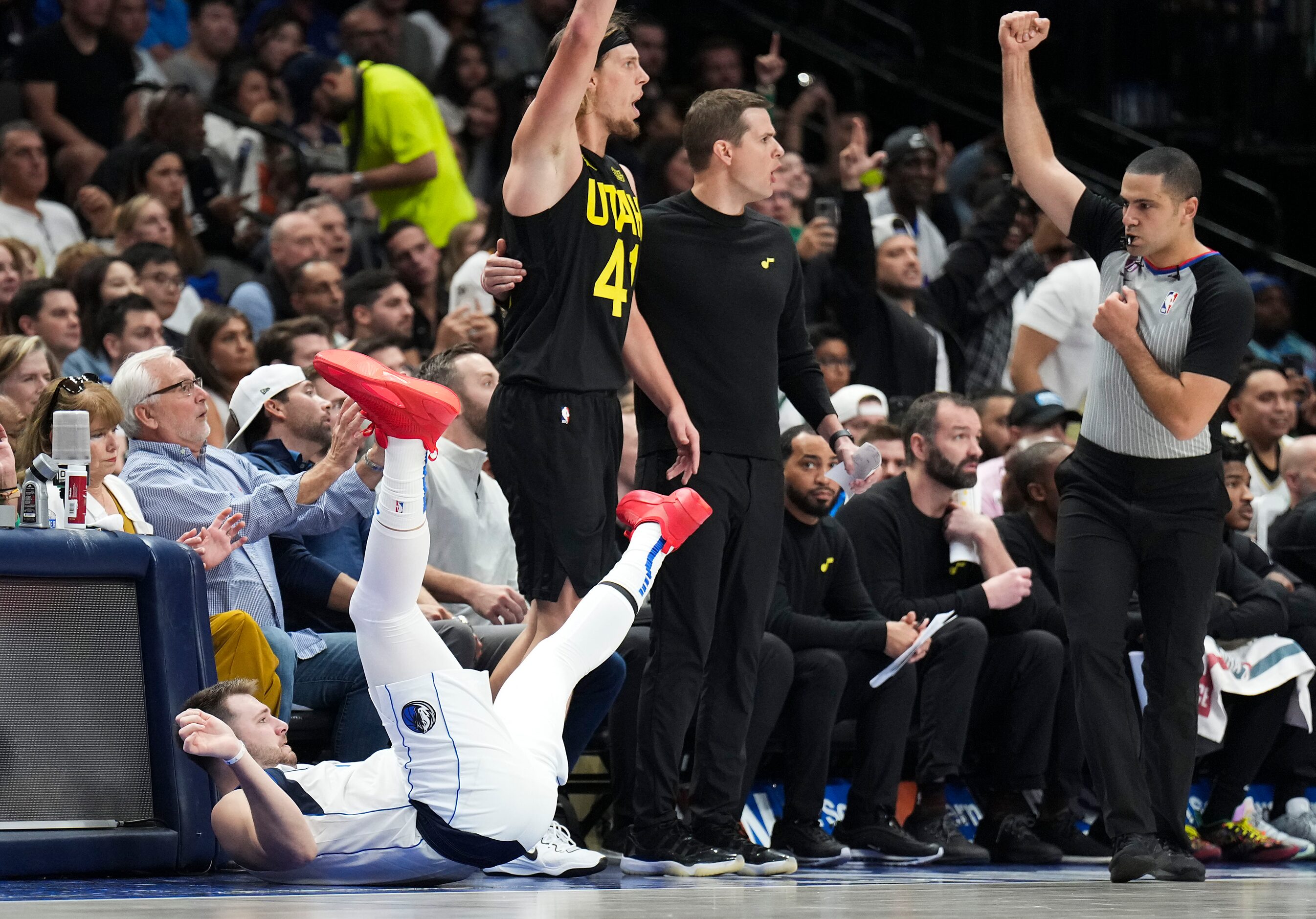 Dallas Mavericks guard Luka Doncic (77) hits the floor after hitting a 3-pointer and being...