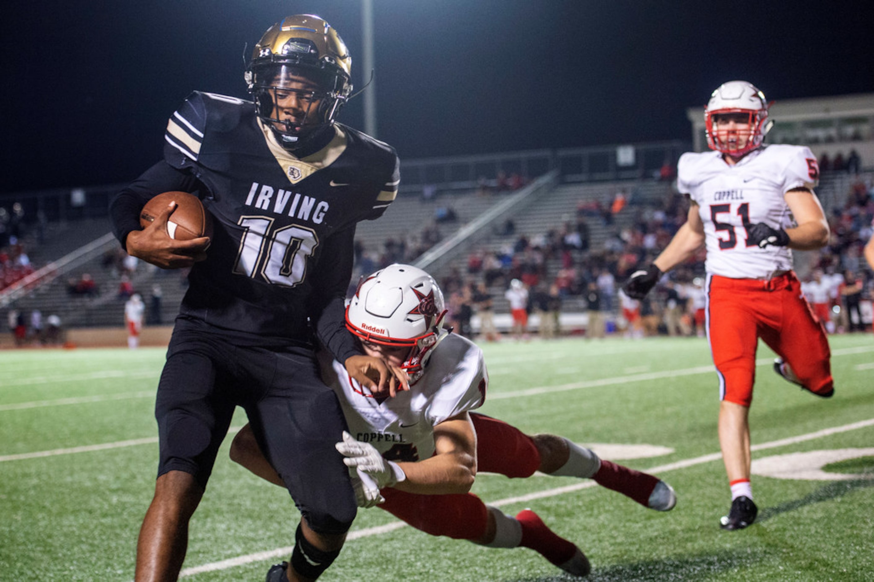 Irving sophomore quarterback Curtis Stevenson (10) is driven out of bounds by Coppell senior...