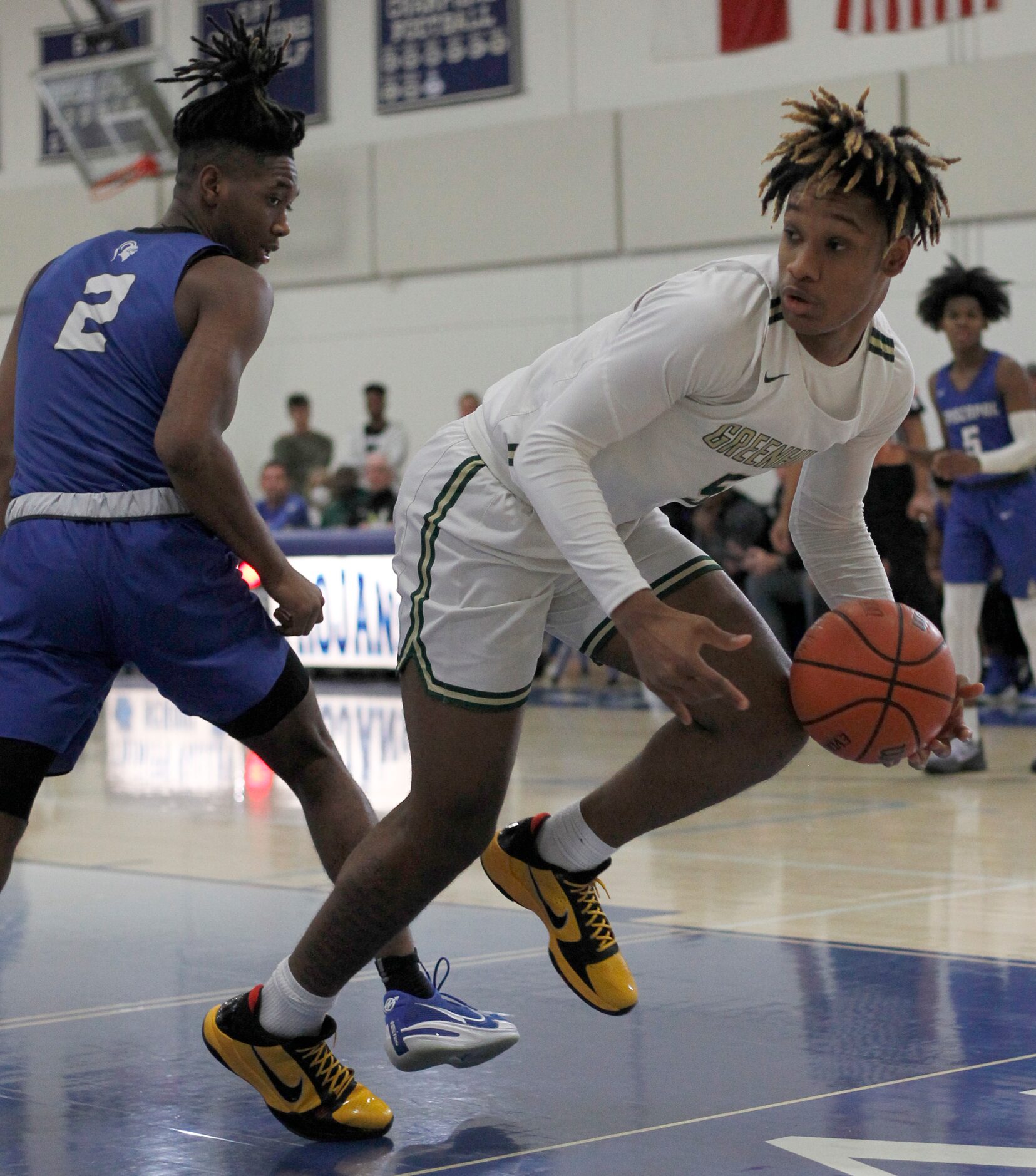 Greenhill's Micah Robinson (5), right, looks to pass along the baseline as Houston...