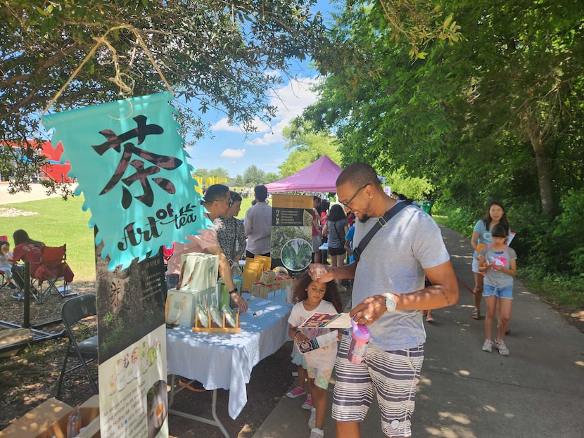 Dax Miller, 39, and his daughters look at the different vendors and organizations featured...