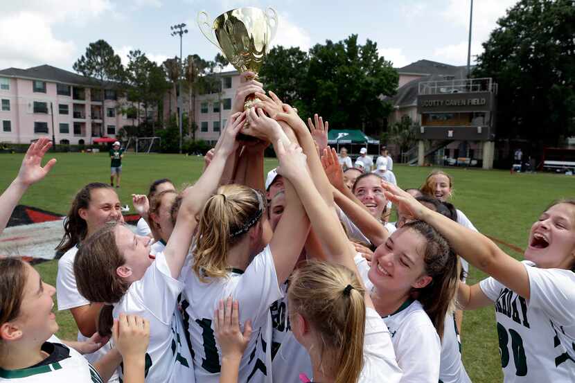 Hockaday players hoist the trophy after their 14-11 win against Southlake Carroll in the...