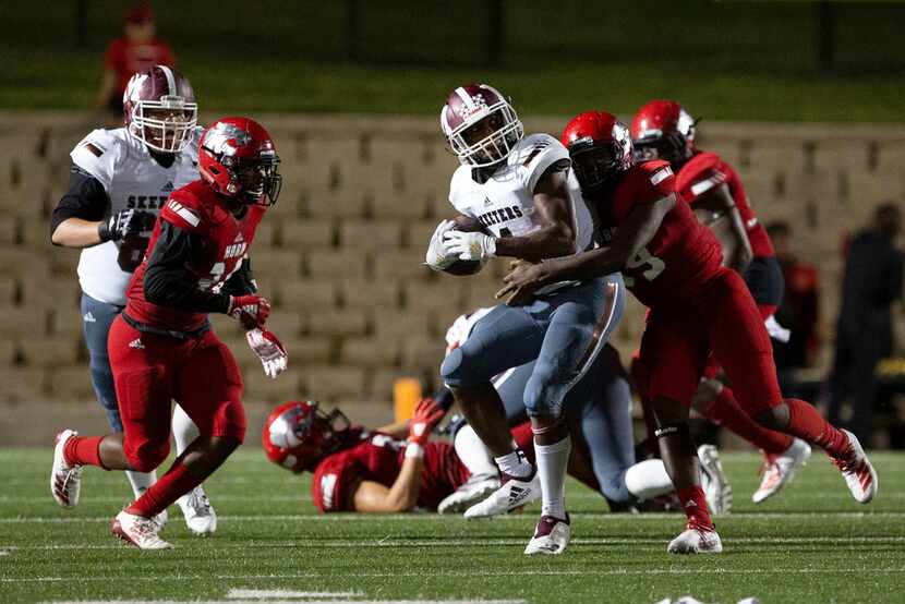 Mesquite Skeeters running back LaDarius Turner (CQ), center, fends off Mesquite HornÃs...