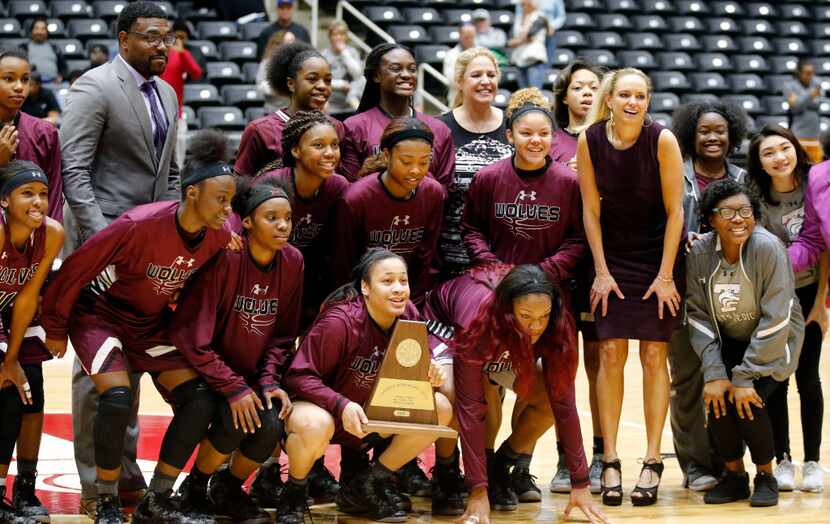 The Mansfield Timberview's Lady Wolves pose with the championship plaque after their 53-47...