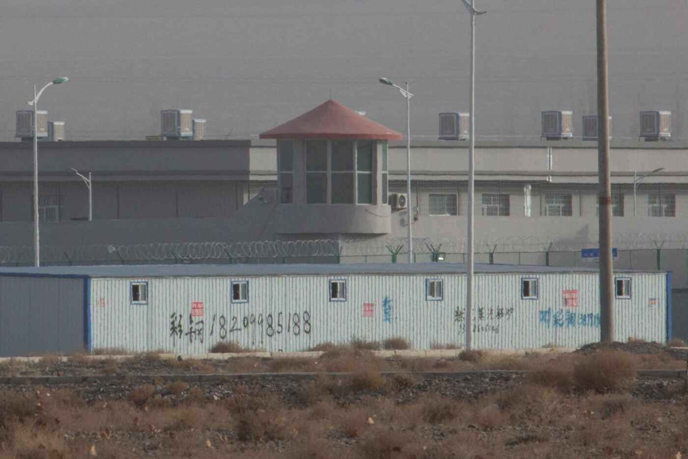 A guard tower and barbed wire fences are seen around a facility in the Kunshan Industrial...