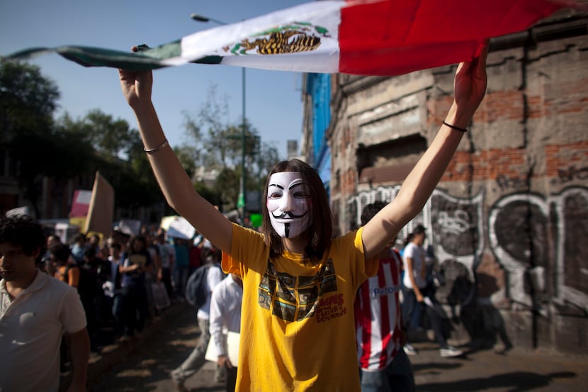 A demonstrator holds up Mexico's national flag during a protest against a possible return of...