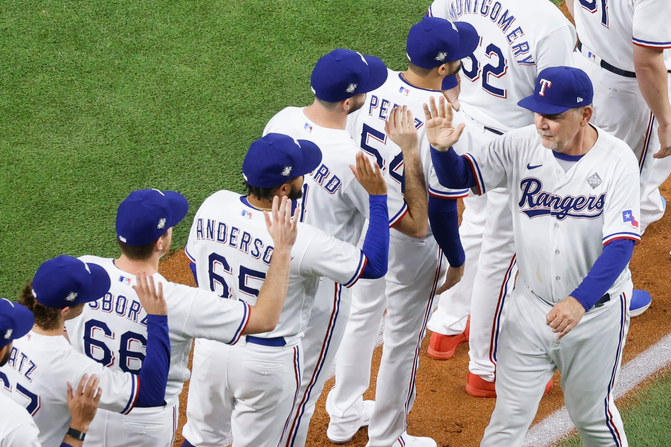 Texas Rangers manager Bruce Bochy high fives players as he is introduced before Game 1 of...