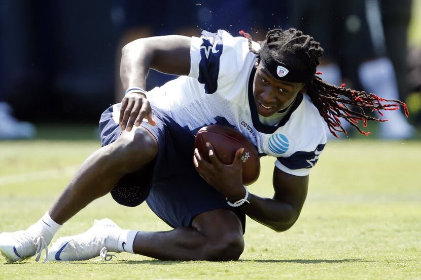 Dallas Cowboys wide receiver Lucky Whitehead (13) rolls over after caching a pass during a...
