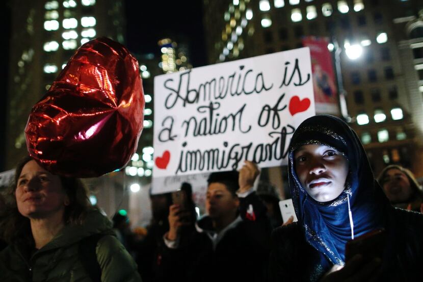 Demonstrators hold signs as the New York Immigration Coalition holds a rally and protest...