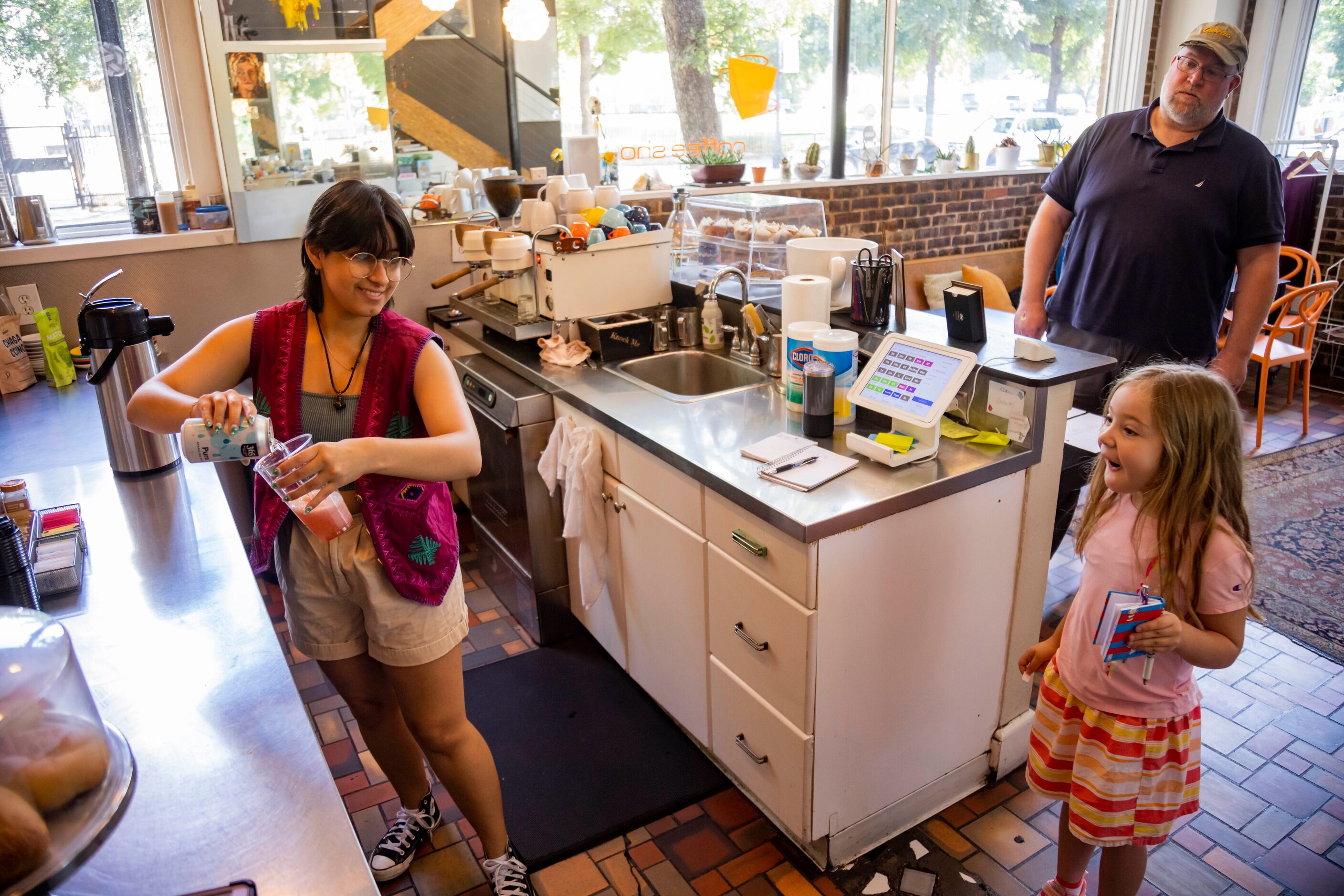 Ellie Jo Dunn, 7, of Fort Worth reacts while seeing barista Sam Vasquez-Lopez prepare her...