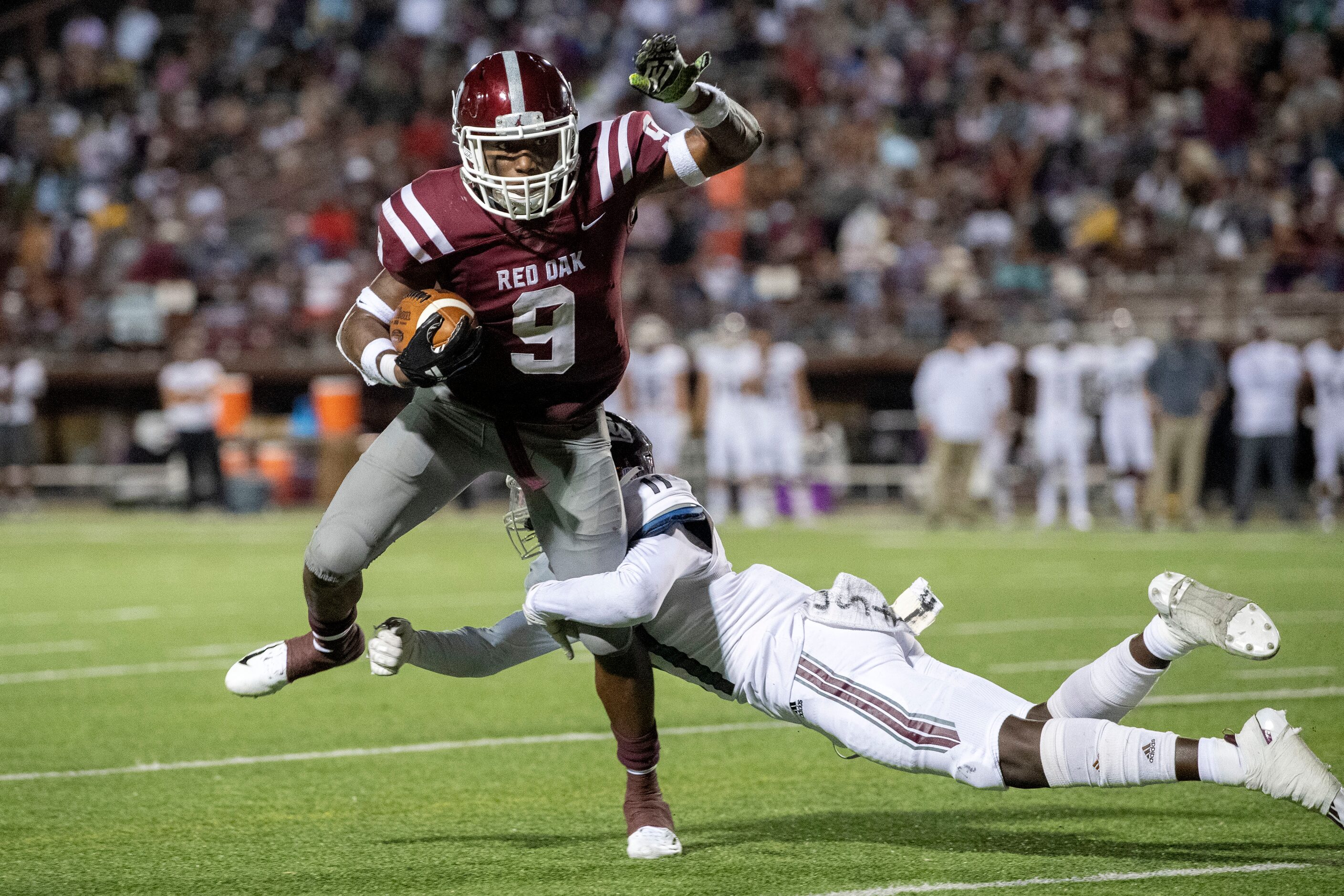 Red Oak senior running back Zach Sanders (9) cannot escape the tackle of Ennis senior...