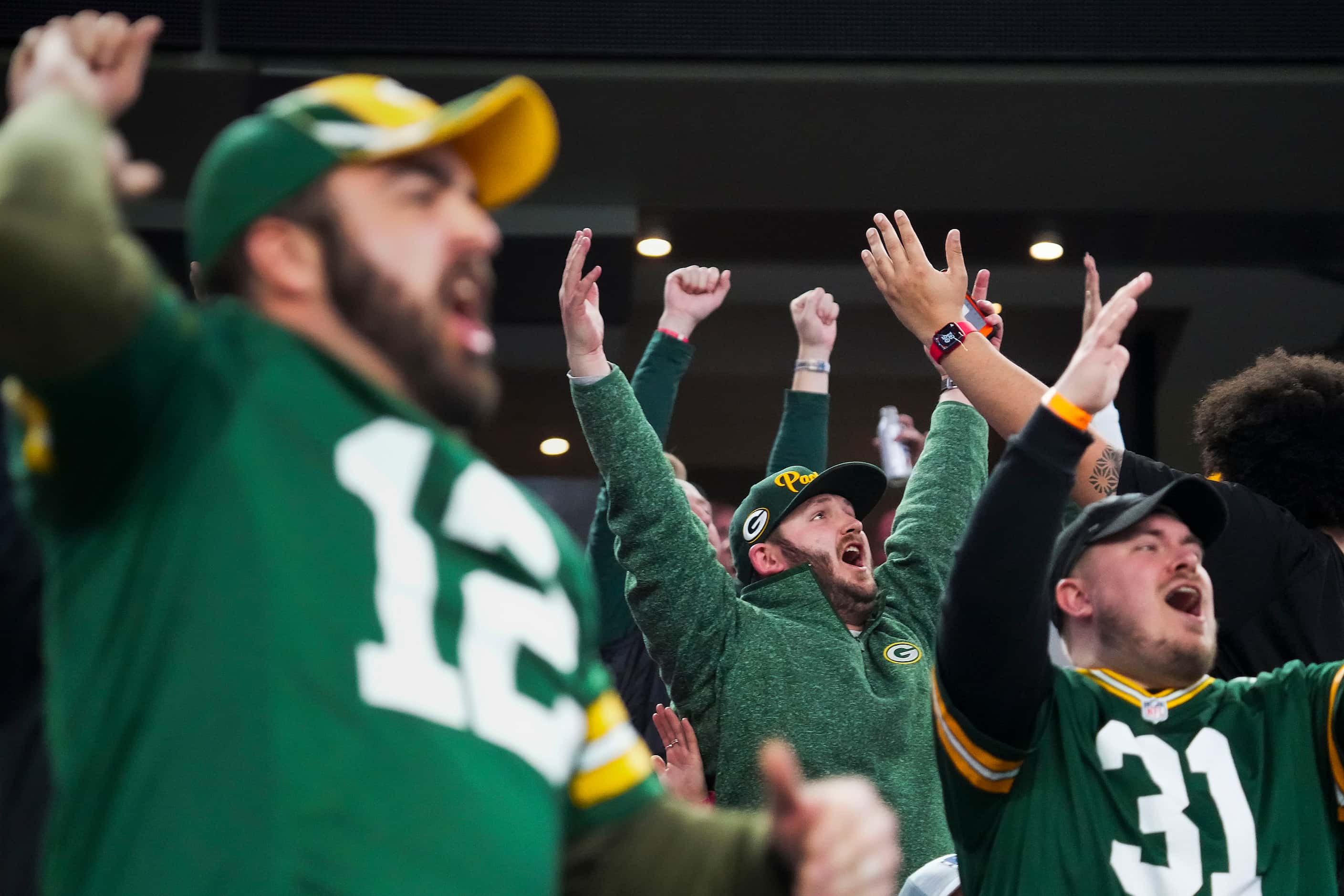 Green Bay Packers fans celebrate after a score during the second half of an NFL wild-card...