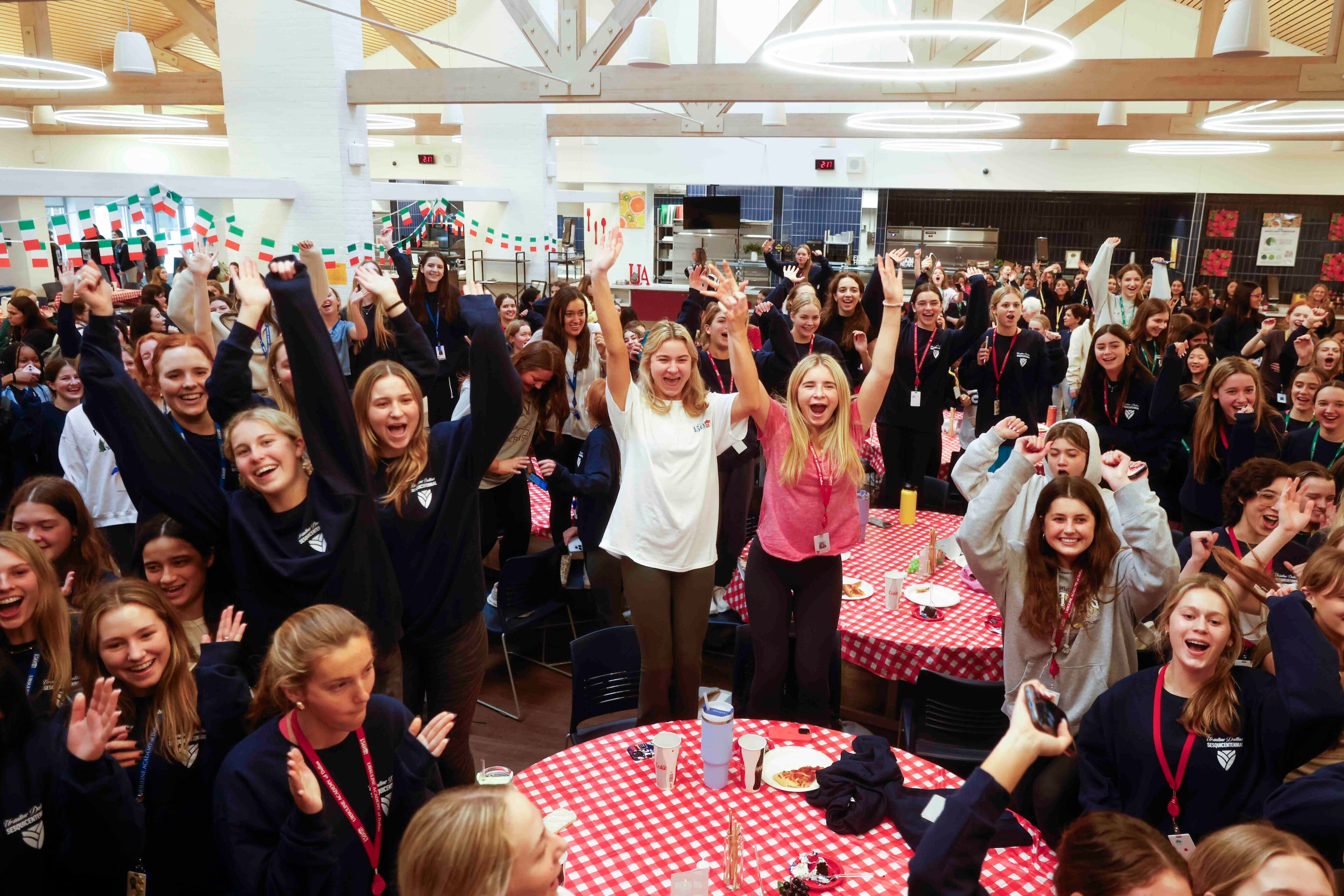 Students react wishing “happy birthday” at the school’s cafeteria during the 150th...