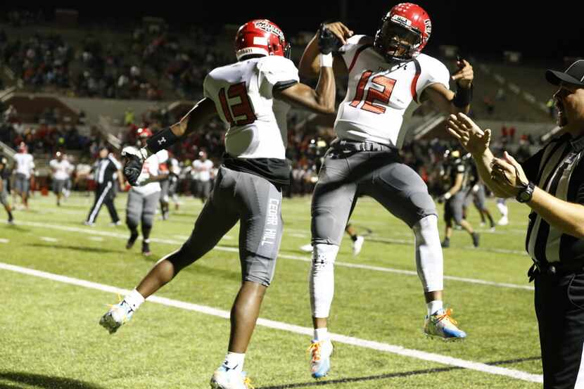 Cedar Hill's Camron Buckley (13) and Avery Davis celebrate after Buckley touchdown in the...