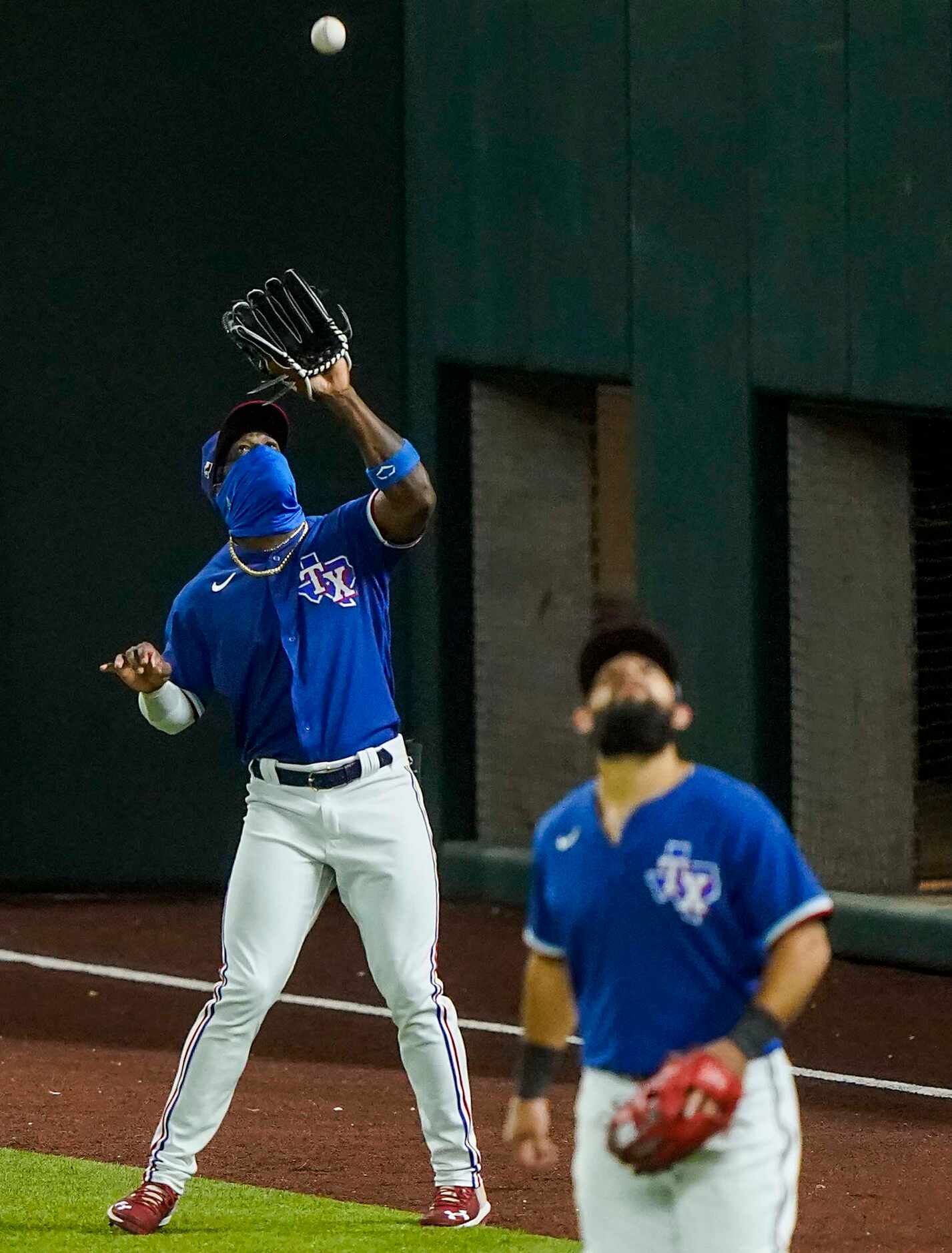 Texas Rangers outfielder Adolis Garcia makes a catch on a fly ball off the bat of Colorado...