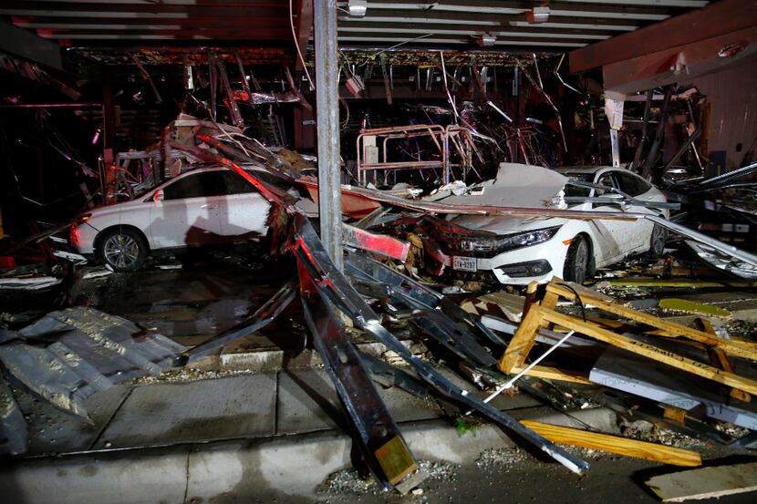 Cars and trucks are damaged as the walls blew out of the I-20 Dodge dealership near Canton...