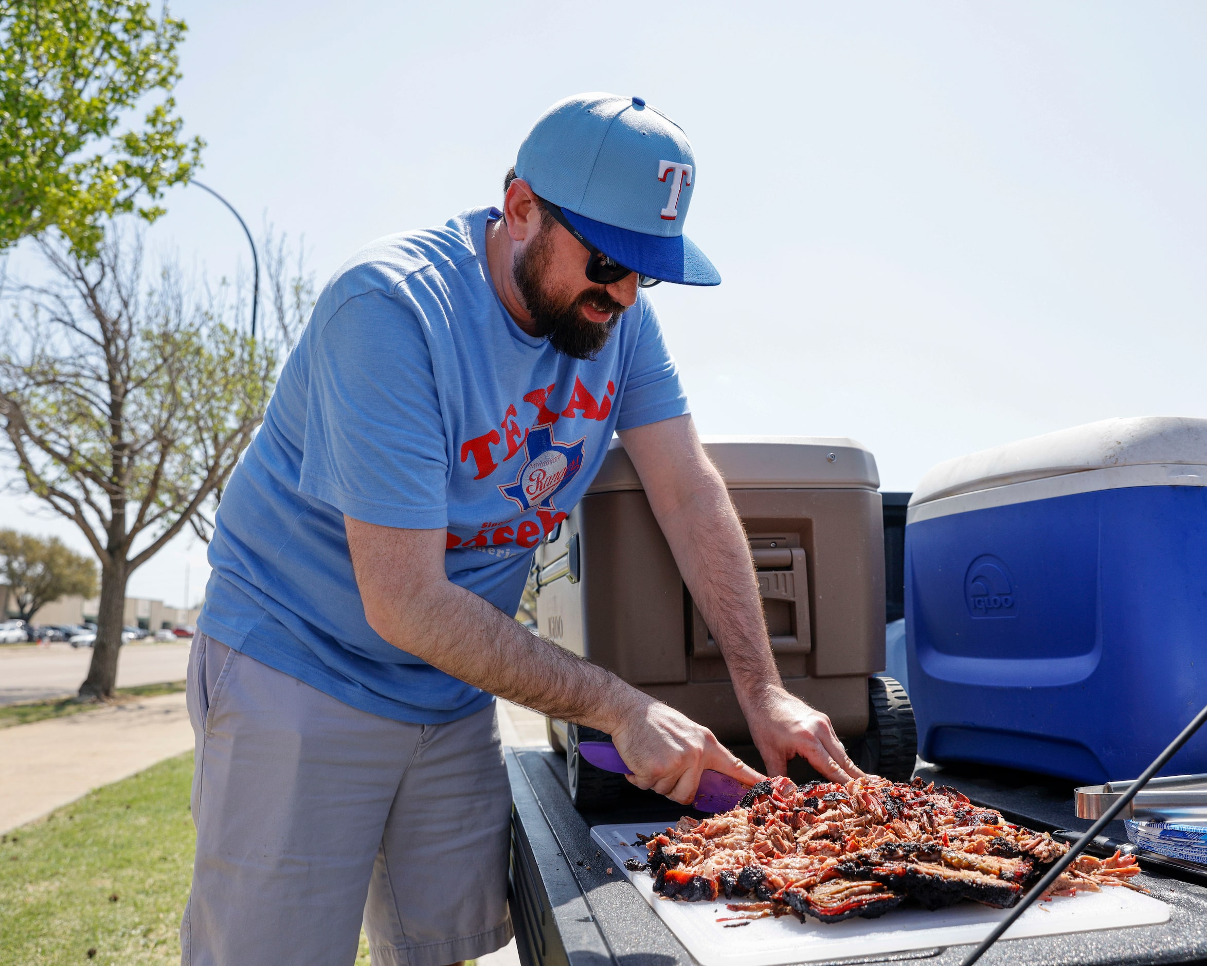 Ray Massey, 38, chops a home-made brisket before the Texas Rangers home opener against the...