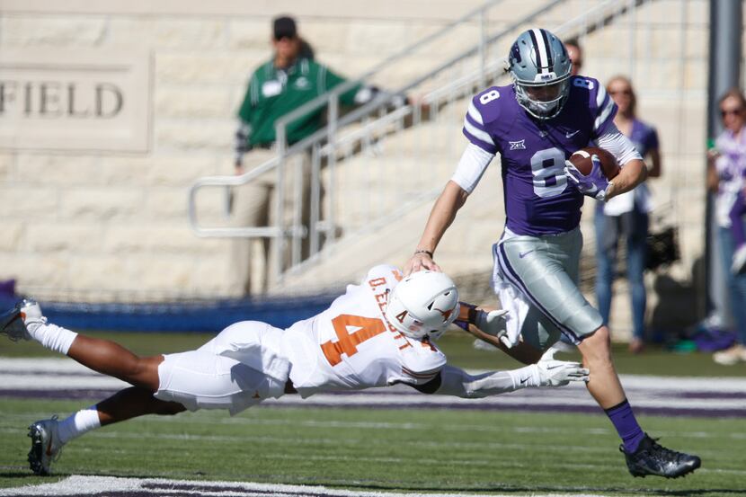Texas safety DeShon Elliott (4) tries to bring down Kansas State quarterback Joe Hubener (8)...
