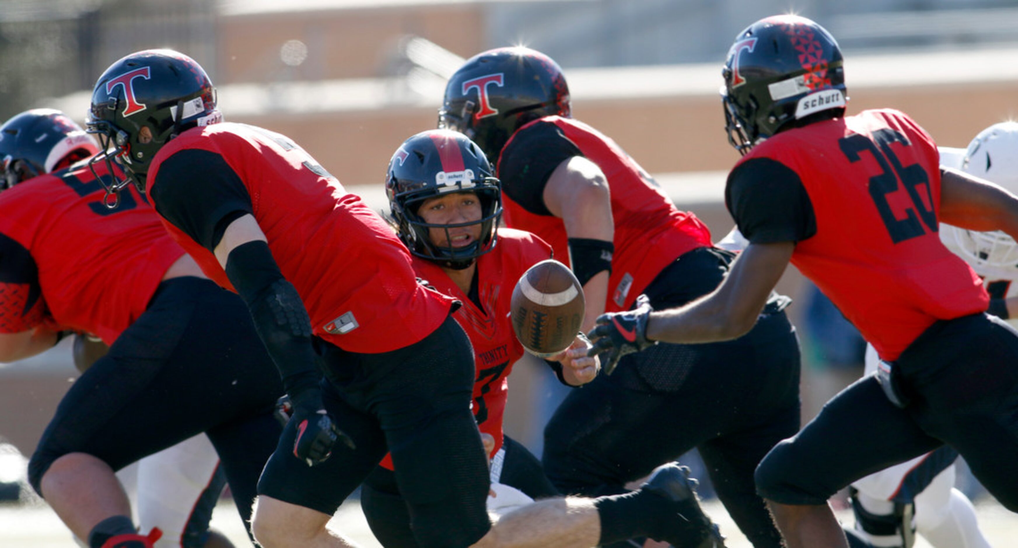 Euless Trinity quarterback Laki Ellis (7) slips as he takes the snap from center but...