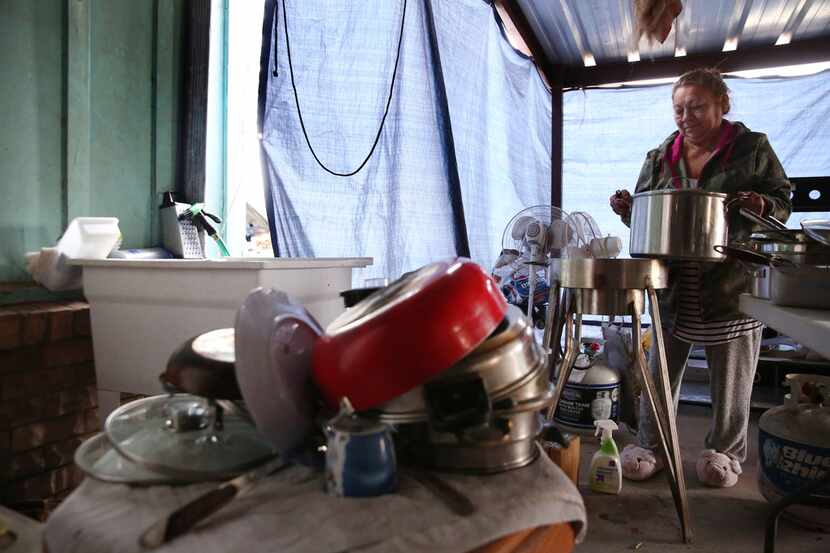 Petra Cervantes cooks soup in her makeshift kitchen outside her home in East Houston, Texas...
