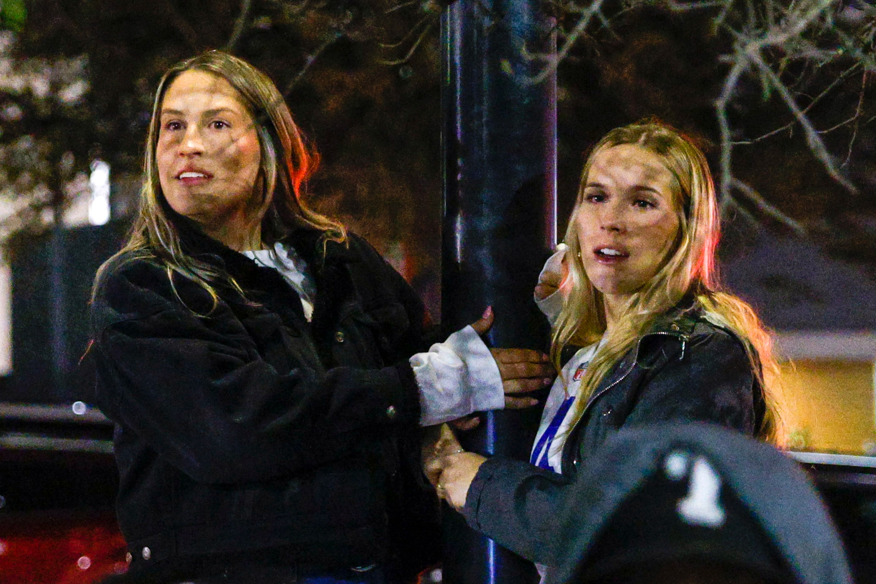 Olivia Ramsay (left) and Brooke Ramsay climb a light pole to watch the end of an NFL...