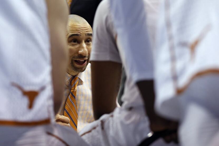 Texas Longhorns head coach Shaka Smart talks to his players during a timeout in a game...