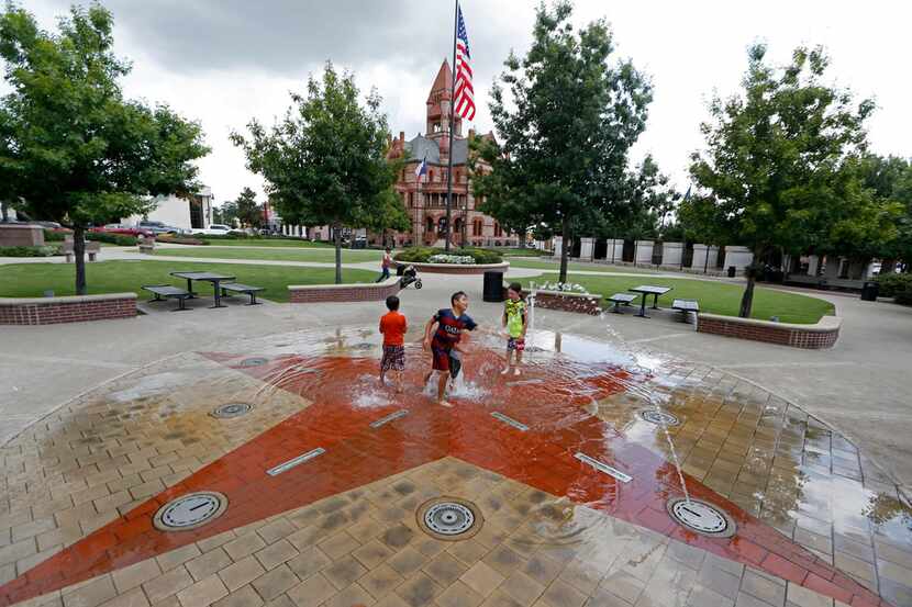Kids play in a fountain in Sulphur Springs.