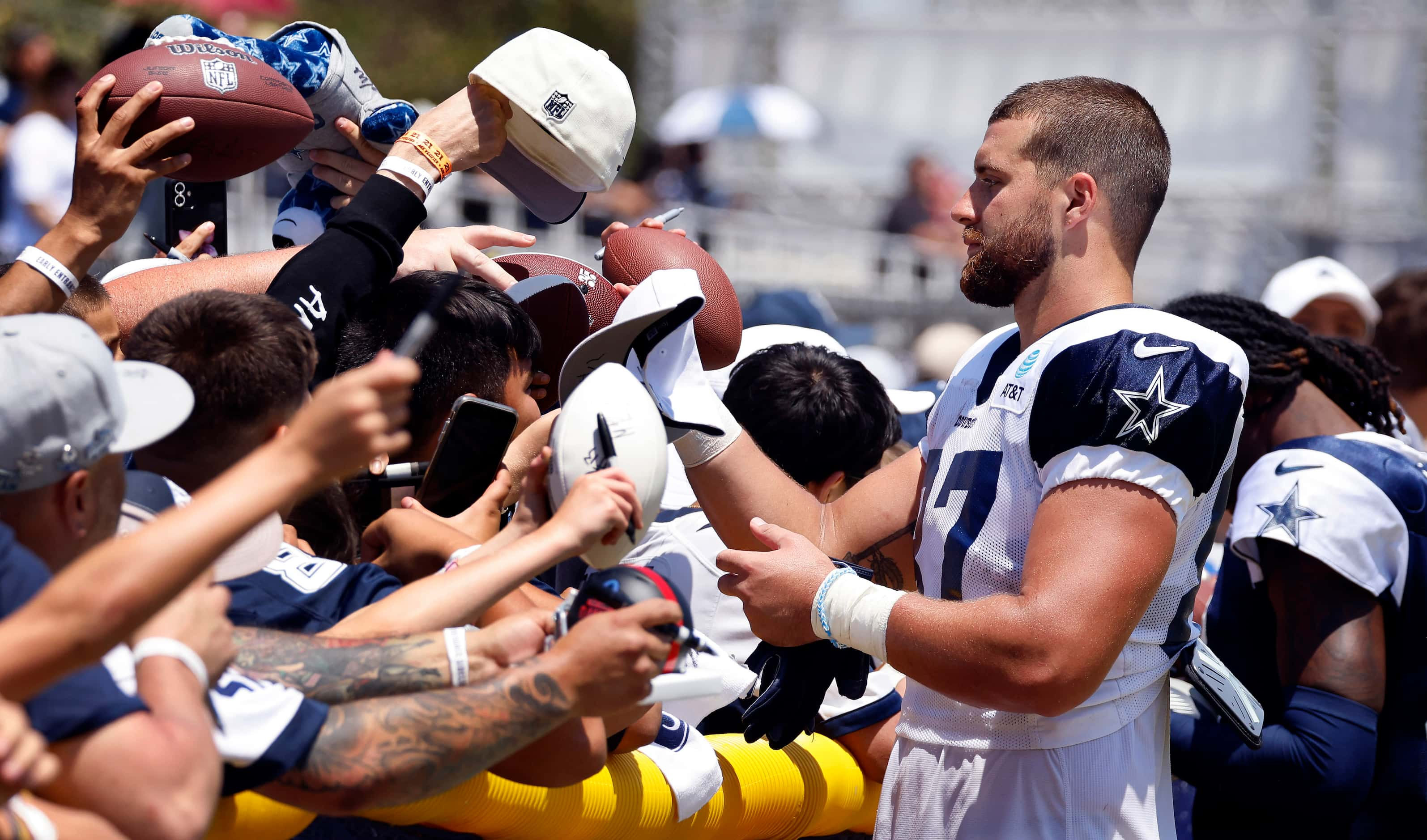 Dallas Cowboys tight end Jake Ferguson (87) signs autographs for a throng of fans following...