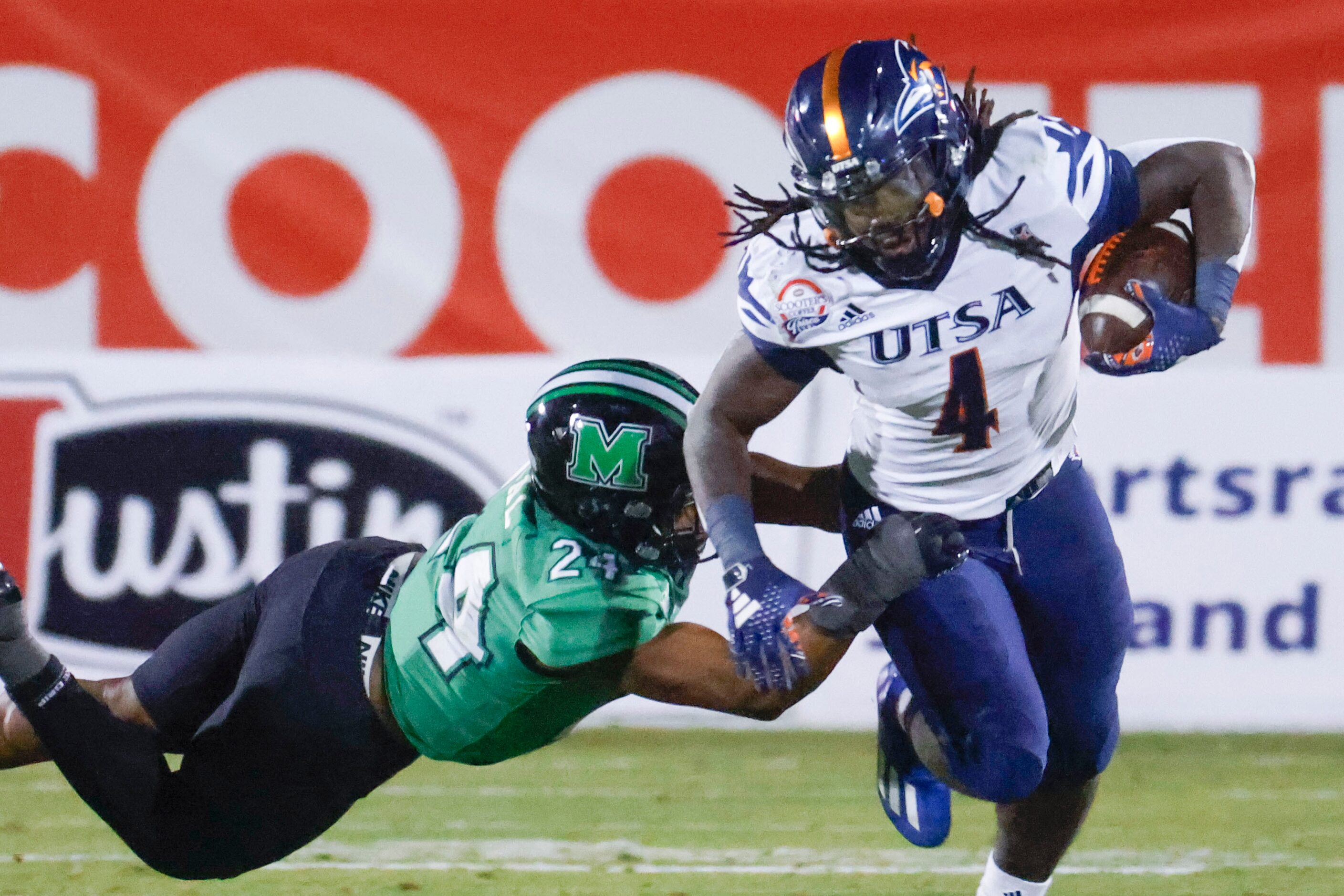 Marshall linebacker Eli Neal (left) tackles UTSA running back Kevorian Barnes during the...