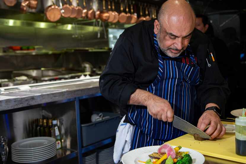 Chef Avner Samuel prepares his Za'atar crusted ahi tuna dish at his restaurant Nosh Bistro...