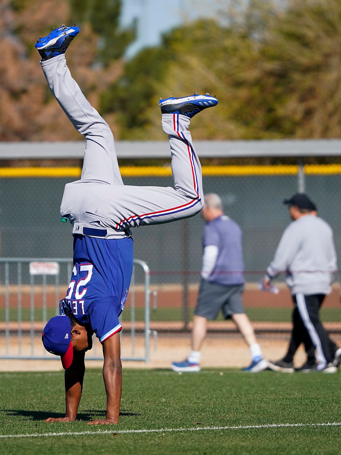 Texas Rangers pitcher Jose Leclerc does a handstand on a conditioning field before a spring...