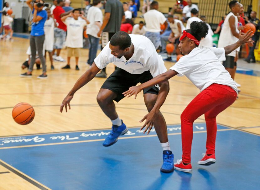 Dallas Mavericks player Harrison Barnes is guarded by Kaila Batts as the NBA player works...