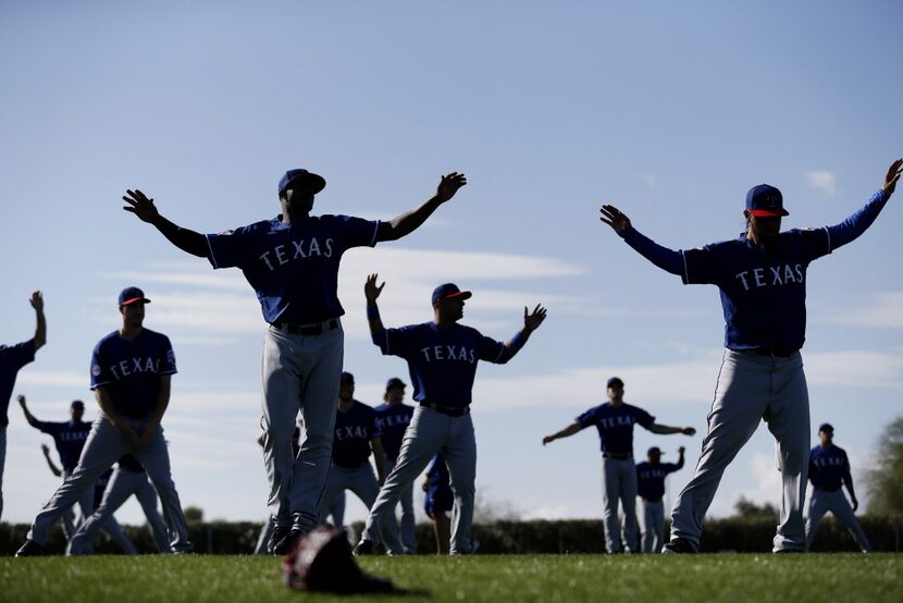 Texas Rangers pitchers stretch before a workout at the Rangers spring training facility at...