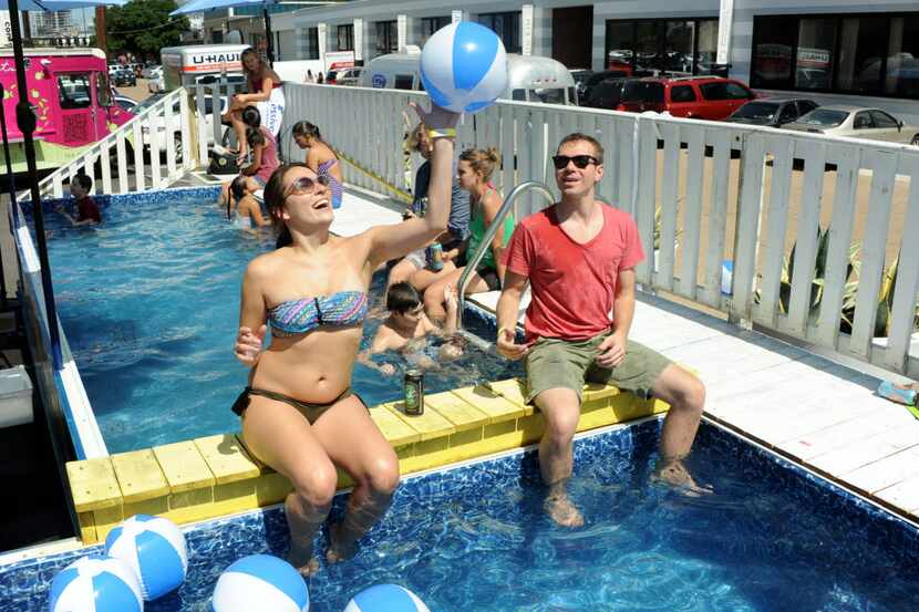 Chelsea Smith and Nathan Myer toss beach balls in the dumpster pool at the Design District...