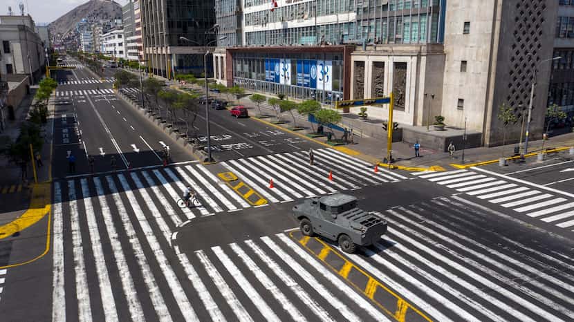 An armored vehicle guards an intersection on Abancay Avenue after the government implemented...