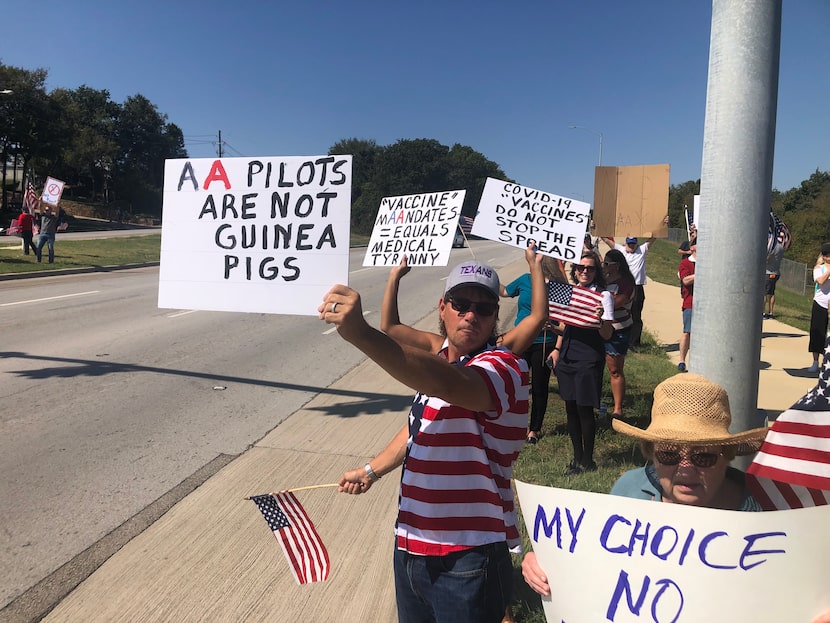 American Airlines pilot Terry Smith holds up a sign protesting vaccine mandates during a...