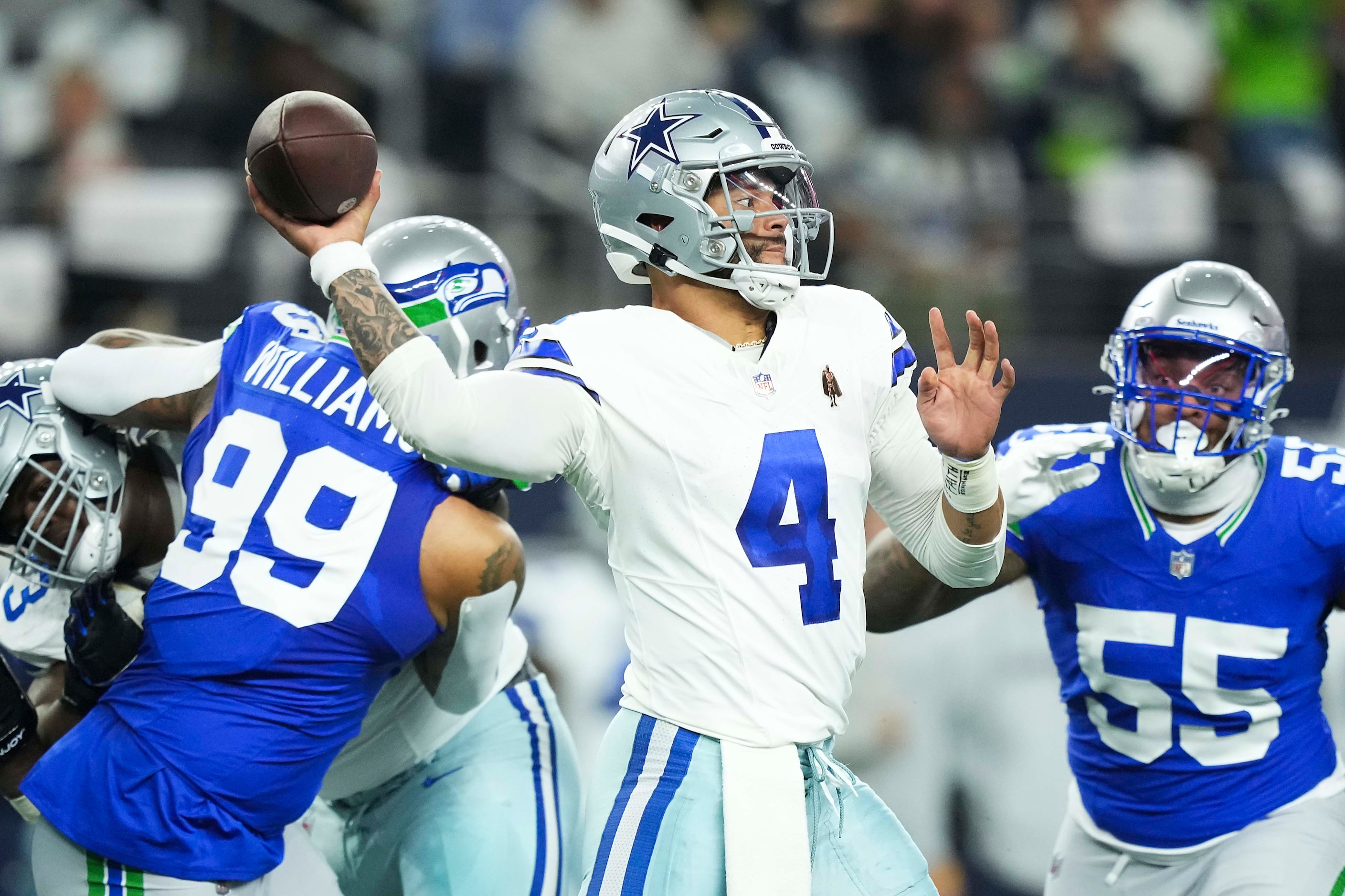 Dallas Cowboys quarterback Dak Prescott (4) throws a pass under pressure from Seattle...