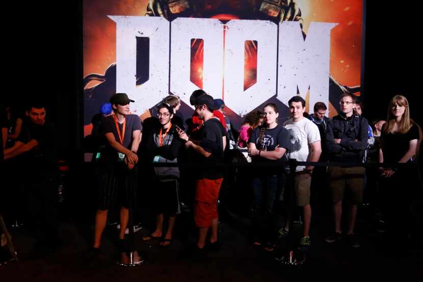 Gamers line up for a free six minute game time with the new Doom game in the exhibit hall at...