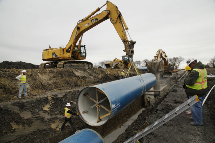 A construction crew installed 50-foot-long sections of pipe on Friday near State Highway 78,...