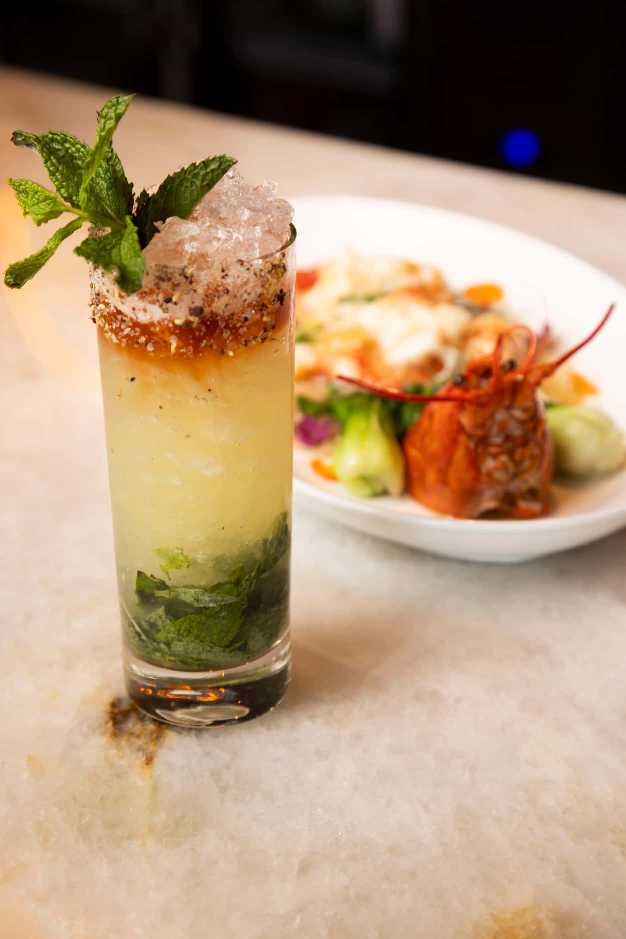 The Szechuan Sauce cocktail is photographed with the Live Maine Lobster at Maison Chinoise...