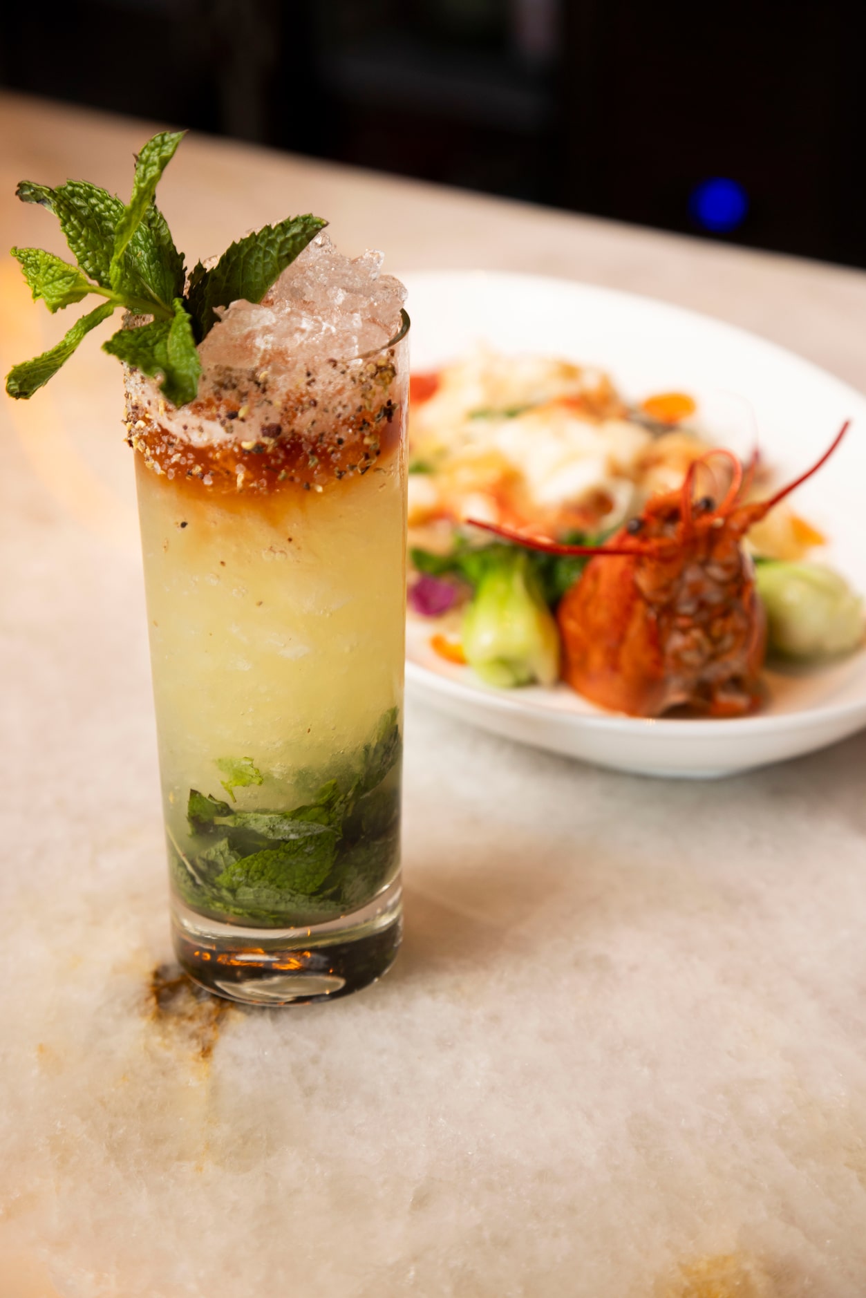 The Szechuan Sauce cocktail is photographed with the Live Maine Lobster at Maison Chinoise...