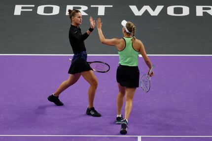 Veronika Kudermetova, left, of Russia, high-fives doubles partner Elise Mertens, right, of...
