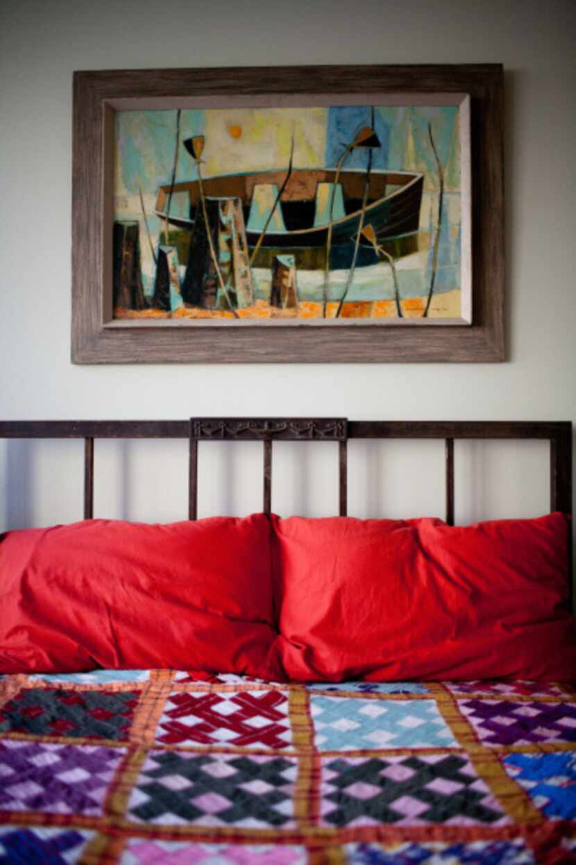 A vintage quilt and artwork add a pop of color to Baker's bedroom