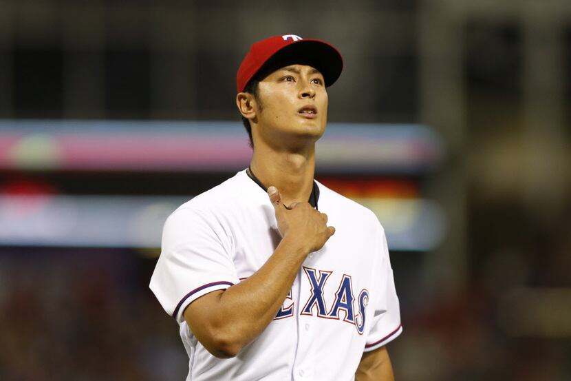 Apr 11, 2014; Arlington, TX, USA; Texas Rangers starting pitcher Yu Darvish (11) heads to...